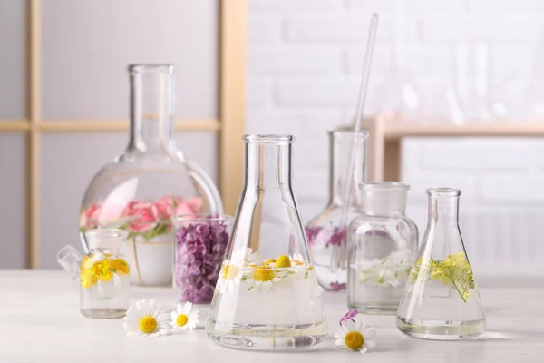 Szkło Laboratoryjne Kwiatami Białym Drewnianym Stole Ekstrakcja Olejku Eterycznego Perfum — Zdjęcie stockowe