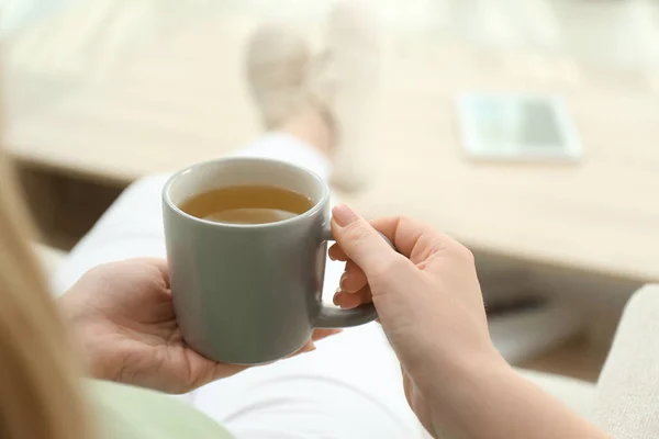 年轻女子在家喝杯热茶放松一下 — 图库照片