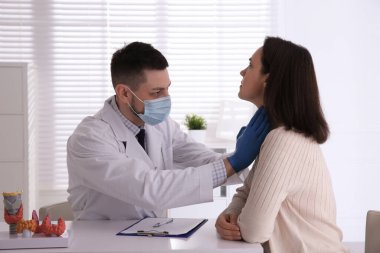 Hastanedeki hastanın tiroit bezini inceleyen doktor.