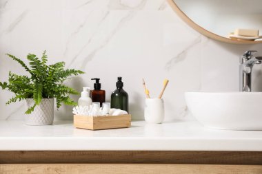 Güzel yeşil eğreltiotu ve banyo tezgahında tuvalet malzemeleri.