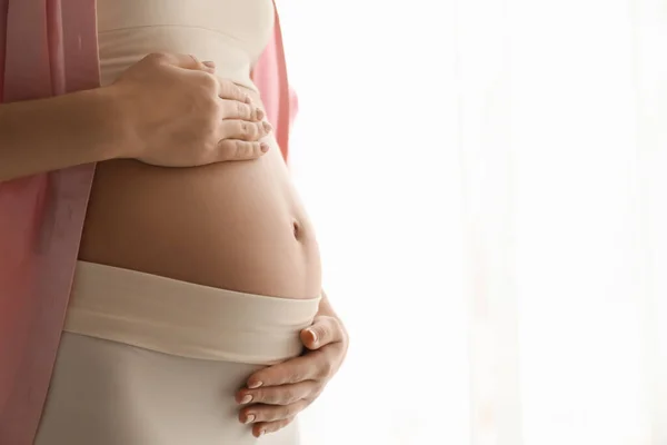 Zwangere Jonge Vrouw Raakt Buik Lichte Achtergrond Close Ruimte Voor — Stockfoto