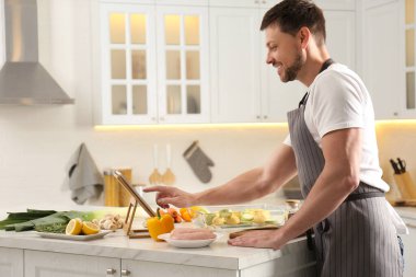 Adam mutfakta tabletten online yemek kursunu izliyor.