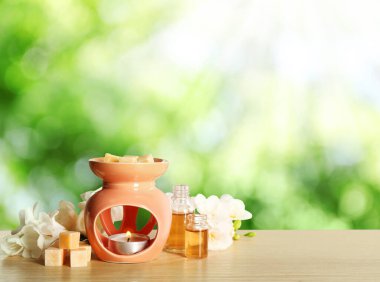 Ahşap masa üzerinde aroma lambası olan kompozisyon, yazı için boşluk. Bokeh etkisi