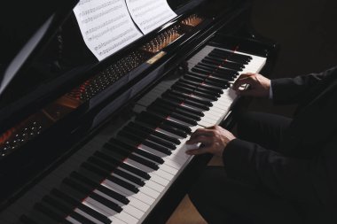 Man playing grand piano, closeup. Talented musician clipart