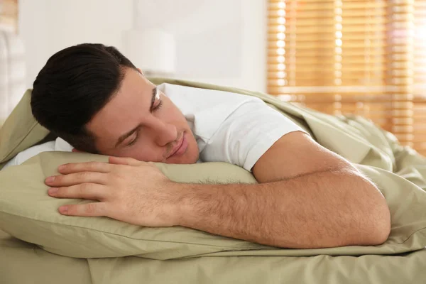 Seorang Pria Tidur Tempat Tidur Dengan Linen Hijau Rumah — Stok Foto