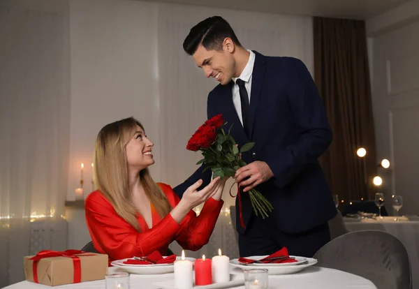 Man Presenterar Rosor Till Sin Älskade Kvinna Restaurang Romantisk Middag — Stockfoto