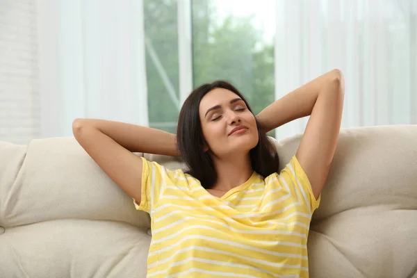 Young woman relaxing on sofa at home