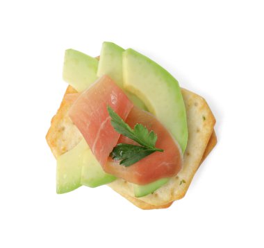 Beyaz arka planda avokado, prosciutto ve maydanozlu leziz krakerler.
