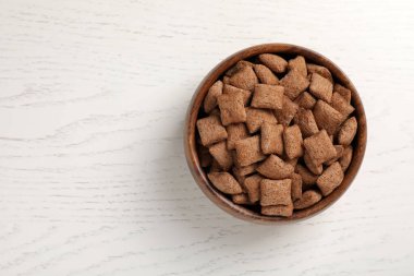 Beyaz ahşap masada kasede mısır gevreği, üst manzara. Metin için boşluk