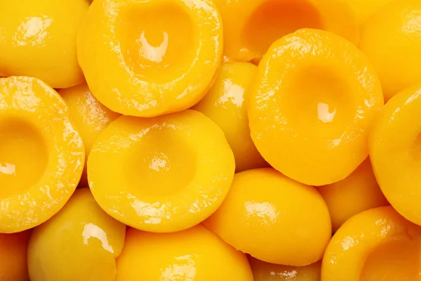 Halves of canned peaches as background, top view