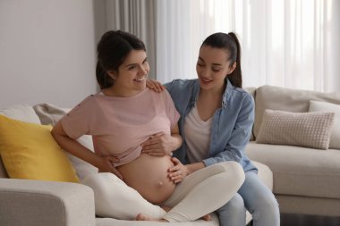 Doula oturma odasında hamile bir kadınla çalışıyor. Çocuk doğumu hazırlığı