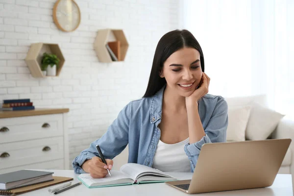 Jonge Vrouw Neemt Aantekeningen Tijdens Online Webinar Aan Tafel Binnen — Stockfoto