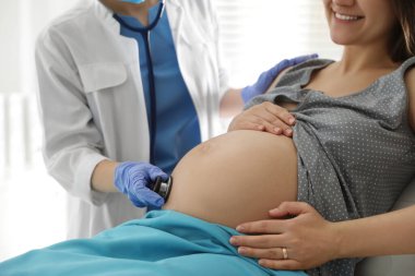 Doğum yapmadan önce kadını muayene eden doktor, yakın plan.
