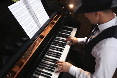 Man playing piano indoors, above view. Talented musician clipart