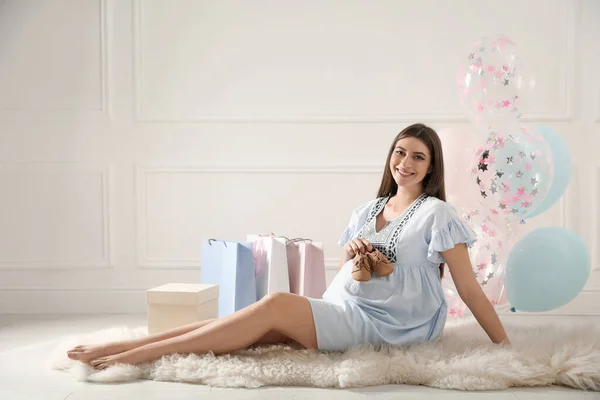 快乐的孕妇 小靴子靠近礼物和气球在室内 婴儿淋浴派对 — 图库照片