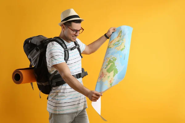 Mężczyzna Turysta Plecakiem Podróżnym Mapą Żółtym Tle — Zdjęcie stockowe
