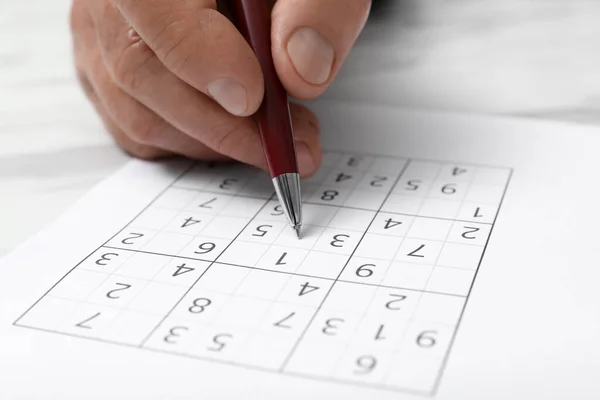 Hombre Mayor Resolviendo Rompecabezas Sudoku Mesa Blanca Primer Plano — Foto de Stock