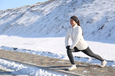 Kadınlar kış günü dışarıda spor egzersizleri yapıyor. Metin için boşluk