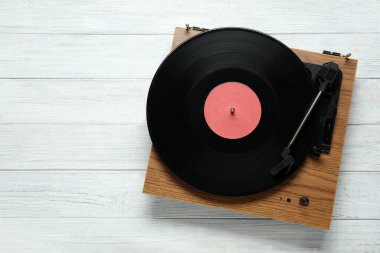 Beyaz ahşap arka planda vinil plağı olan bir döner masa. Metin için boşluk