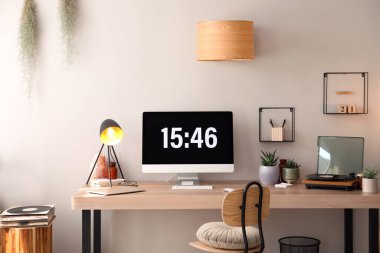 Modern bilgisayar ve dizüstü bilgisayar odasındaki ahşap masada. İç tasarım