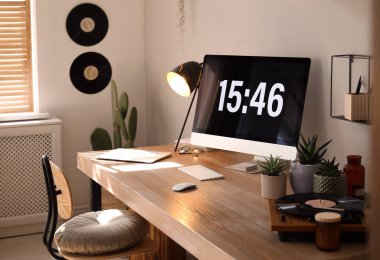 Rahat işyeri olan bir oda. Ahşap masadaki modern bilgisayar