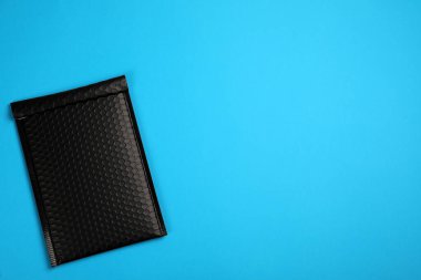 Açık mavi arkaplanlı, baloncuk ambalajlı bir zarf, üst manzara. Metin için boşluk