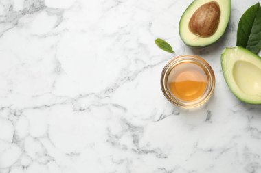 Temel yağ ve avokadoyla bembeyaz mermer masanın üzerinde düz bir bileşim vardı. Metin için boşluk