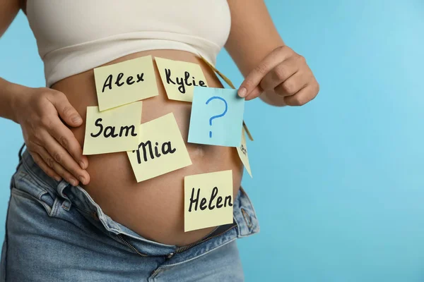 Mulher Grávida Com Diferentes Nomes Bebê Barriga Contra Fundo Azul — Fotografia de Stock