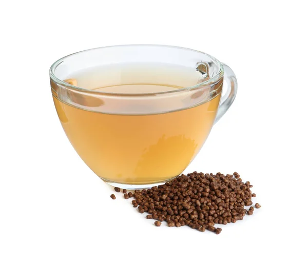 stock image Glass cup of buckwheat tea and granules on white background