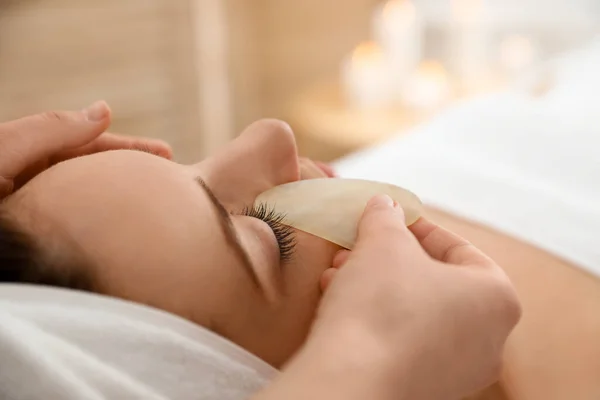 Jovem Mulher Recebendo Massagem Facial Com Ferramenta Gua Sha Salão — Fotografia de Stock