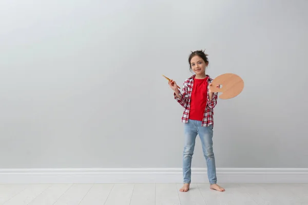 Bambina Con Pennello Tavolozza Colori Vicino Alla Parete Grigio Chiaro — Foto Stock