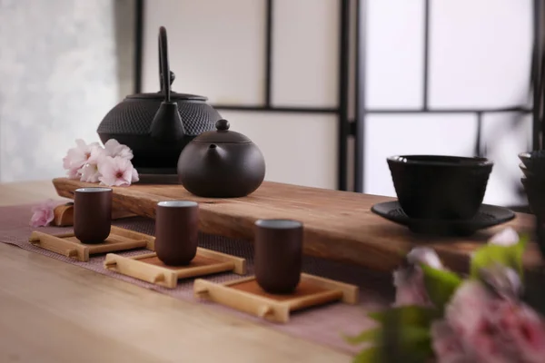 木製のテーブルの上に伝統的な茶道や桜の花のための美しいセット — ストック写真