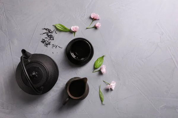 薄灰色のテーブルに美しい伝統的な茶道セットと桜の花 フラットレイアウト テキストのスペース — ストック写真