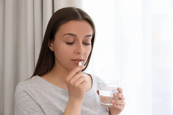 Ung Kvinna Med Glas Vatten Tar Piller Hemma — Stockfoto