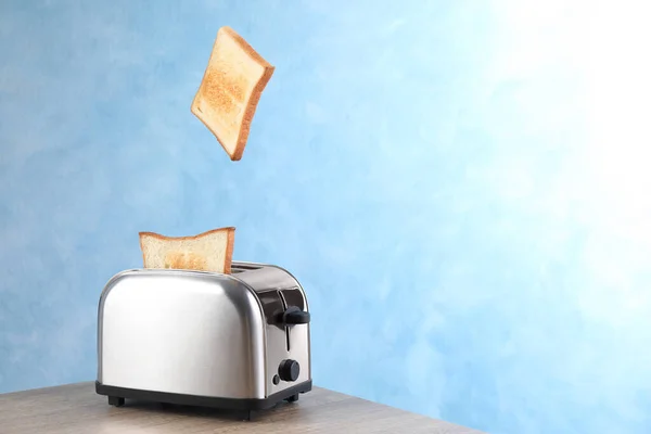 Brotscheiben Die Aus Dem Modernen Toaster Auf Dem Holztisch Auftauchen — Stockfoto