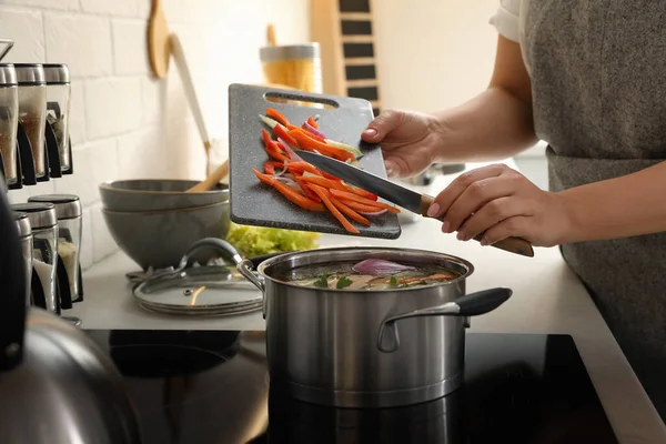 야채를 남비에 맛있는 부용을 주방의 스토브에 응고시킨다 — 스톡 사진