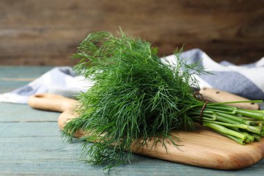 Bunch of fresh dill on light blue wooden table clipart