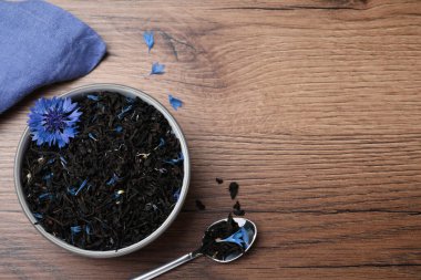 Kurutulmuş mısır çiçeği çayı ve ahşap masada taze çiçekler, düz uzanmış. Metin için boşluk