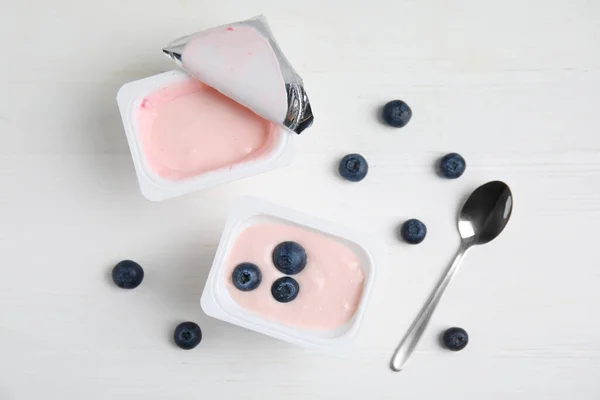 Plastik Cangkir Dengan Yogurt Lezat Dan Blueberry Atas Meja Kayu — Stok Foto