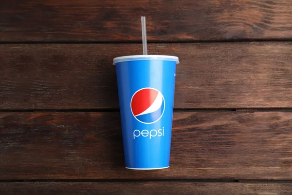 MYKOLAIV, UKRAINE - HAZİRAN 08, 2021: Ahşap zemin üzerinde kağıt Pepsi bardağı, üst görünüm