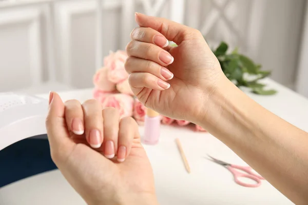 Mujer Haciendo Manicura Con Lámpara Uñas Ultravioleta Mesa Blanca Primer — Foto de Stock