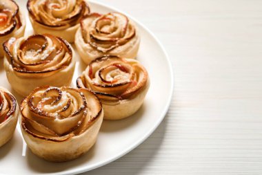 Beyaz ahşap masada taze pişmiş elma gülleri, yazı için yer. Güzel tatlı.