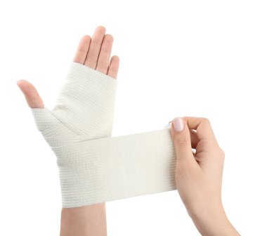 Beyaz arka plana tıbbi bandaj yapıştıran kadın, yakın plan.