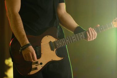 Sahnede elektro gitar çalan adam, yakın plan. Rock müzik