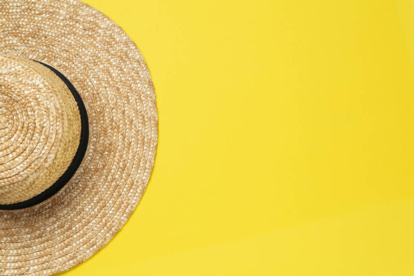 Straw hat on yellow background, top view with space for text. Sun protection