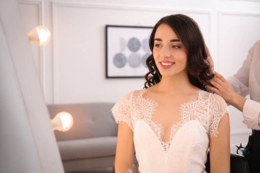 Stililist müşteriyle kuaförde çalışıyor, düğün saç stili yapıyor.