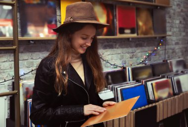 Mağazada plak kaydı olan genç bir kadın var.