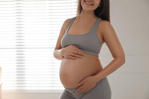 Mulher Jovem Grávida Tocando Barriga Perto Janela Dentro Casa Close — Fotografia de Stock