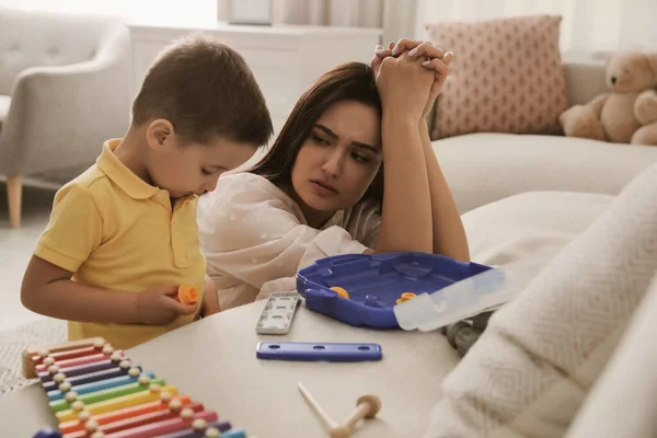 Depressed single mother with child in living room