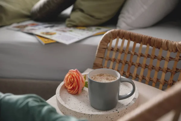 Kaffee Und Rosenblüte Auf Korbsessel Neben Bett Drinnen — Stockfoto